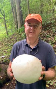 Shawn with giant puffball mushroom that is bigger than his head!