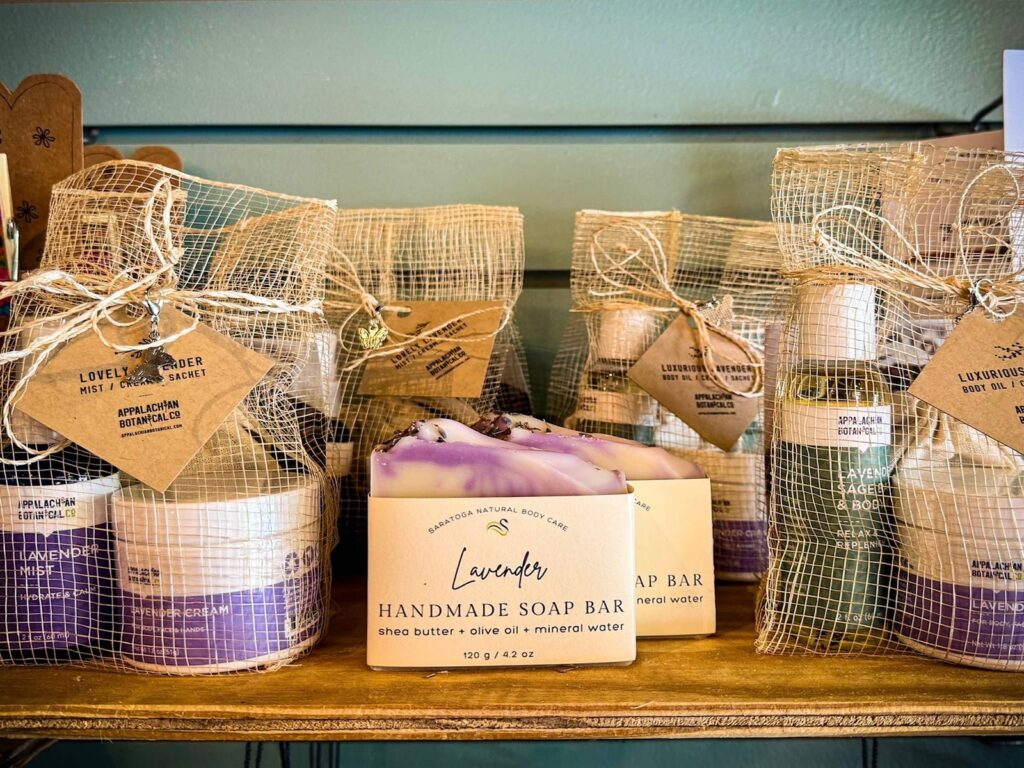 A shelf of lavender mists and lotions in mesh bags with Appalachian Botanical Co. labels on each.