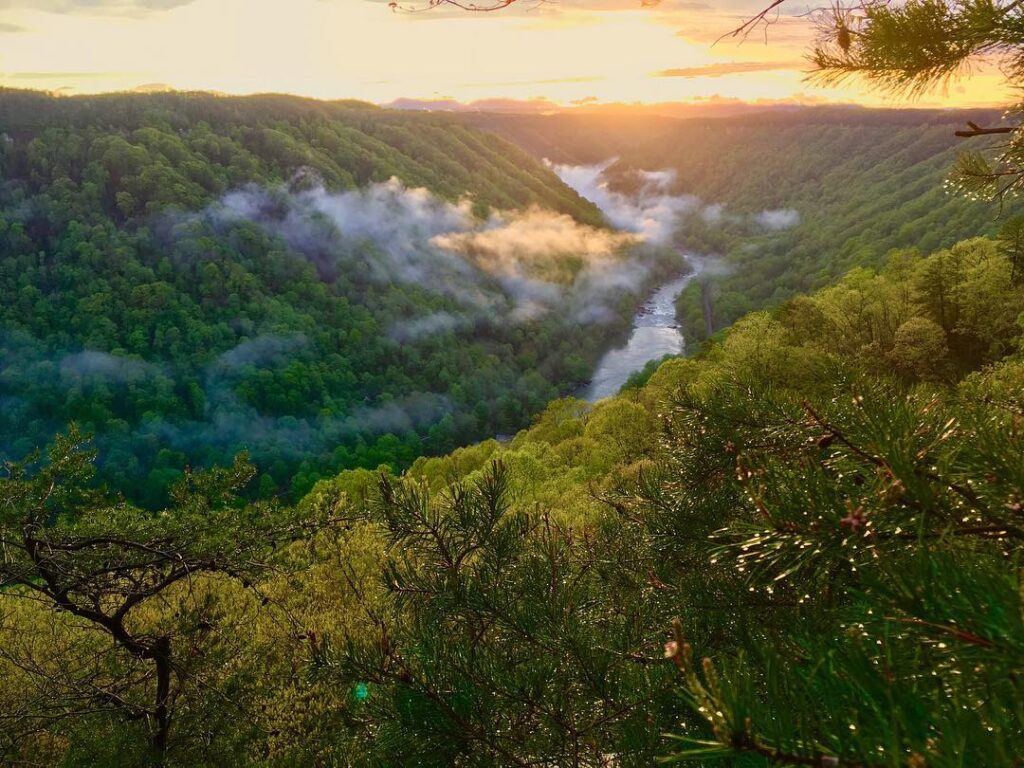 Sunset in the New River Gorge National Park with fog rolling through the canyon. 
