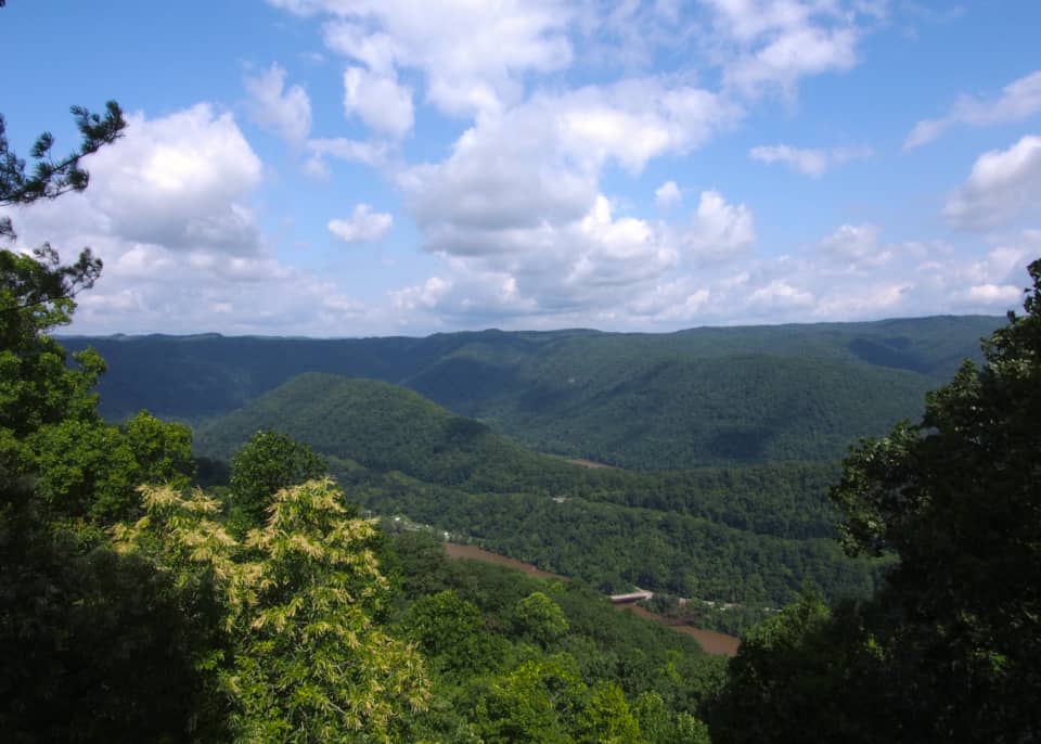 The view looking north from Turkey Spur Overlook. The New River and Stretcher Neck Mountain are visible on this hazy summer day in the New River Gorge. 