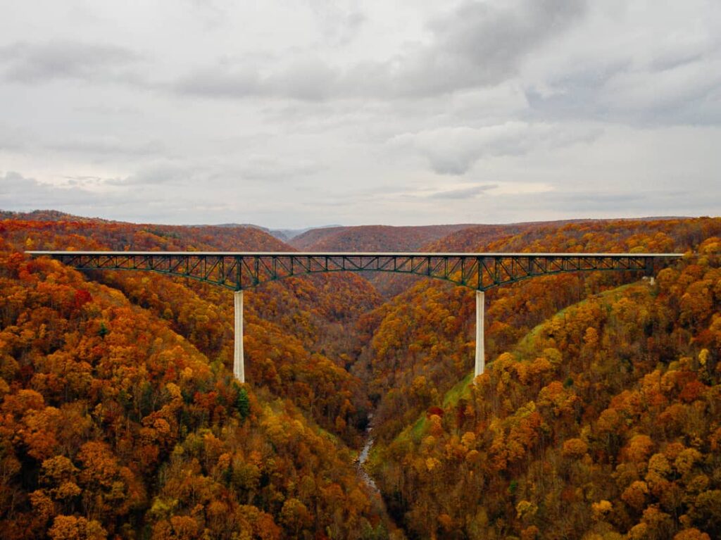 The I64 bridge above Glade Creek in central section of the New River Gorge National Park.  The mountains on both sides of the bridge are covered in autumn leaves of flaming red, yellow and orange.