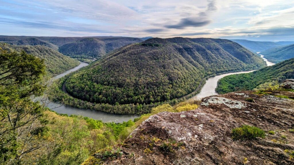 The horseshoe bend in the New River as it flows past Backus Mountain. The trees are in full green bloom at the bottom of the mountain but the trees at the top are still bare of leaves. 