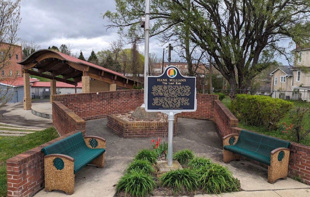 An Alabama state marker sign in the middle of a little outdoor seating area in Oak Hill, WV. It is a tribute to country music star Hank Williams. 