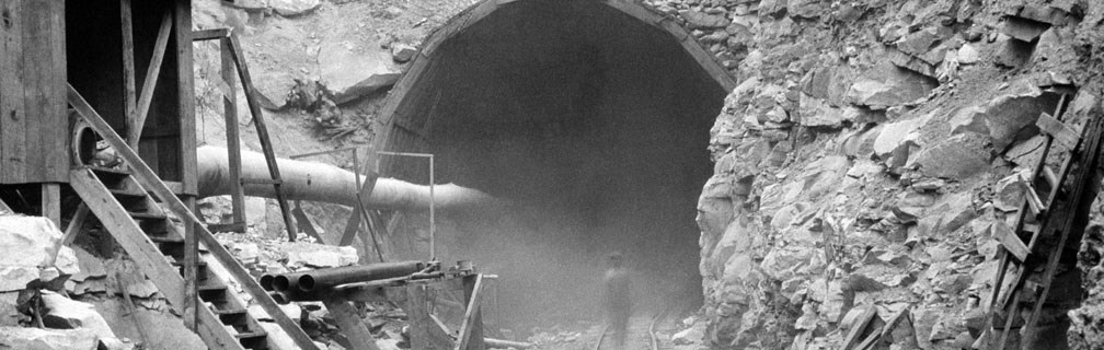 An old black and white photo of a tunnel about 24' tall under construction at Hawks Nest. 