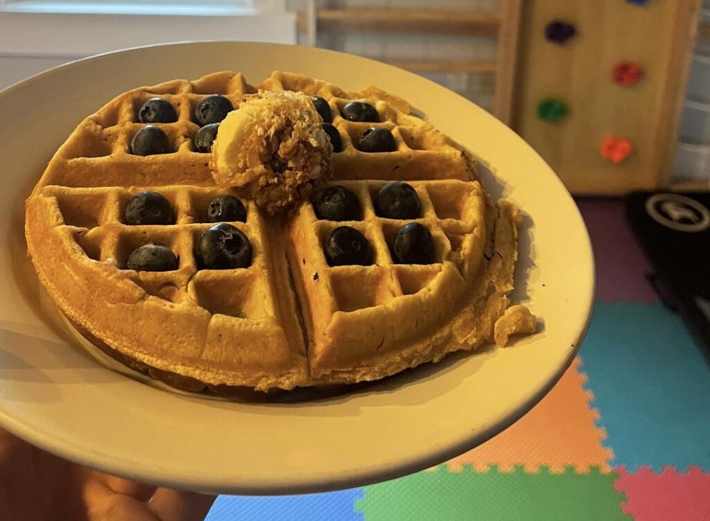 A big waffle with blueberries and butter on top at Wood Iron Eatery. 